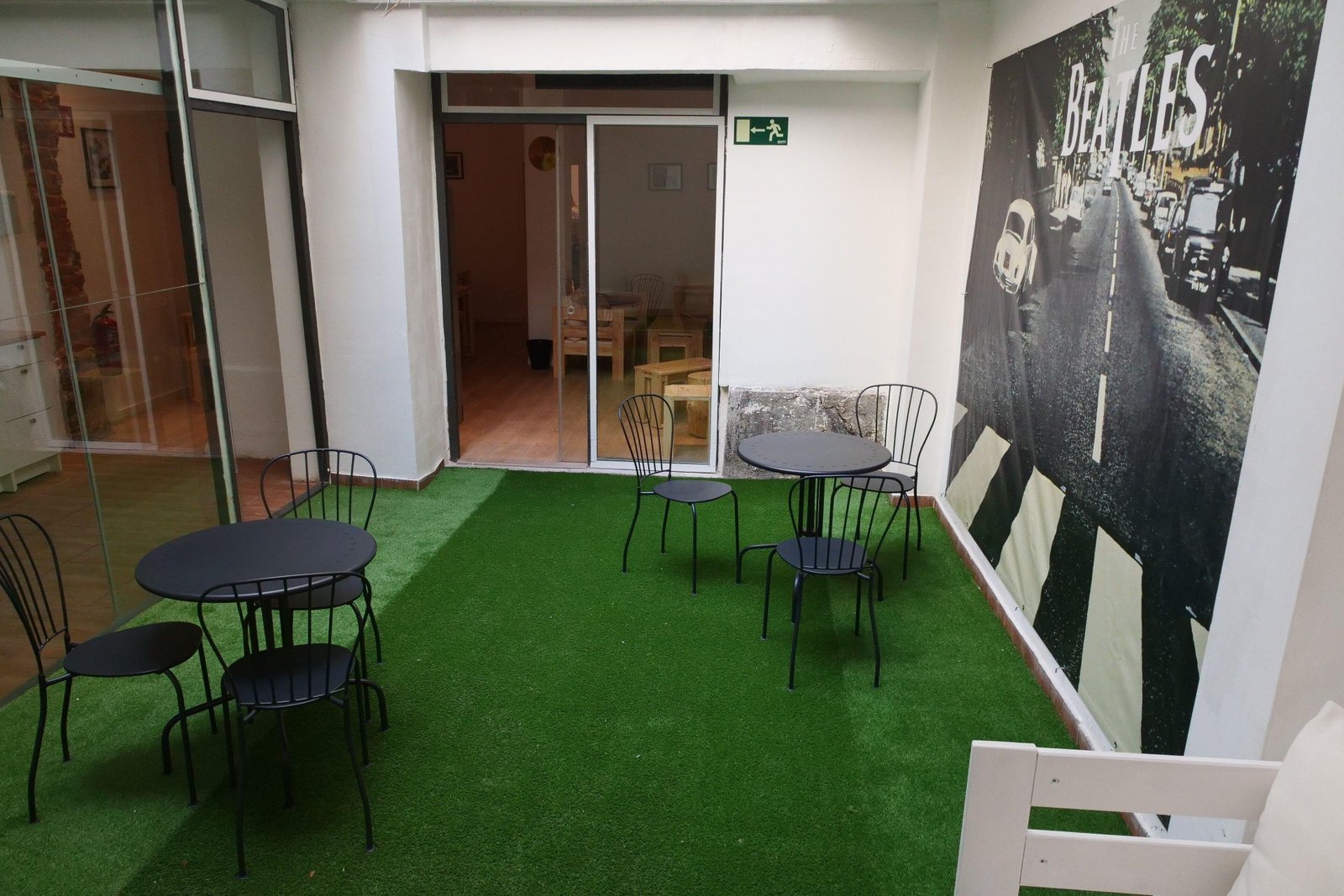 El patio del hostel, con césped y póster de Abbey Road
